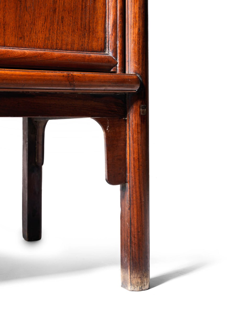 Joinery detail showing cabinet leg and apron with soft wear.